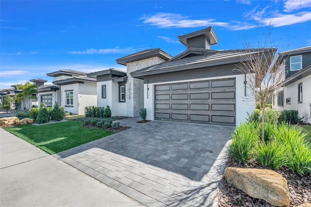 3024 Kensington Ave, Davenport, FL 33837 - prairie-style home with an attached garage, stucco siding, a front yard, and decorative driveway