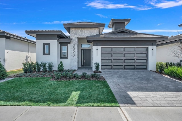 3024 Kensington Ave, Davenport, FL 33837 - prairie-style house featuring stucco siding, decorative driveway, a front yard, a tile roof, and a garage