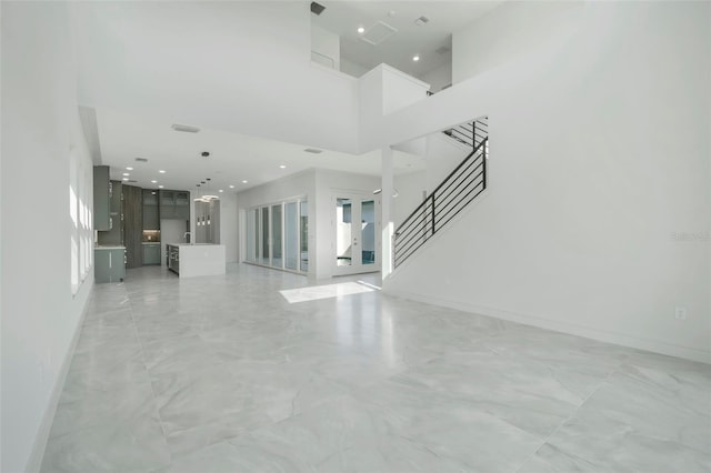 3024 Kensington Ave, Davenport, FL 33837 - unfurnished living room with baseboards, recessed lighting, a high ceiling, stairs, and marble finish floor
