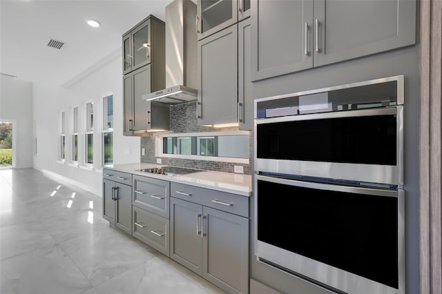 3024 Kensington Ave, Davenport, FL 33837 - kitchen with tasteful backsplash, visible vents, wall chimney exhaust hood, double oven, and gray cabinetry