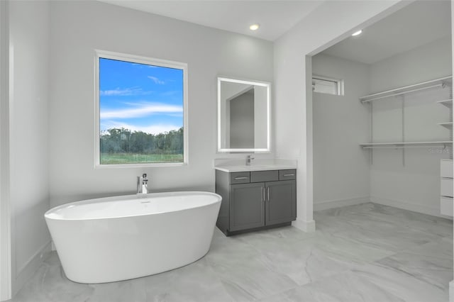 3024 Kensington Ave, Davenport, FL 33837 - full bathroom with vanity, baseboards, recessed lighting, a freestanding bath, and marble finish floor