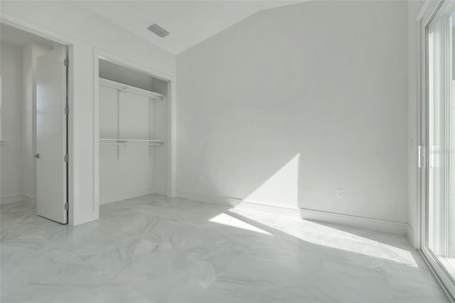 3024 Kensington Ave, Davenport, FL 33837 - unfurnished bedroom with a closet, vaulted ceiling, visible vents, marble finish floor, and baseboards
