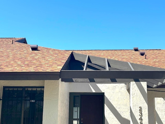 details with stucco siding and roof with shingles