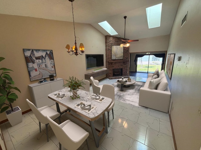 dining space with marble finish floor, an inviting chandelier, visible vents, vaulted ceiling with skylight, and a brick fireplace