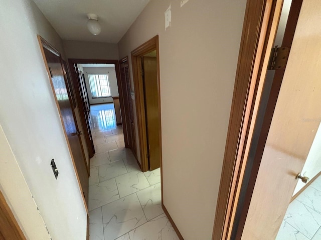 corridor featuring marble finish floor
