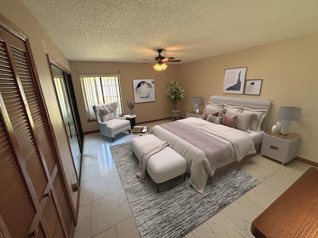 bedroom featuring marble finish floor, baseboards, a ceiling fan, and a textured ceiling