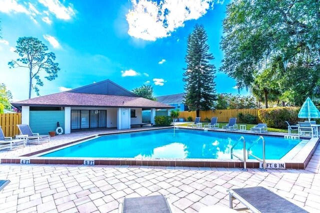 community pool featuring fence and a patio area
