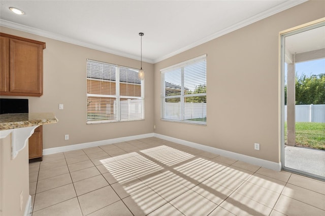 unfurnished dining area with light tile patterned floors, baseboards, and crown molding