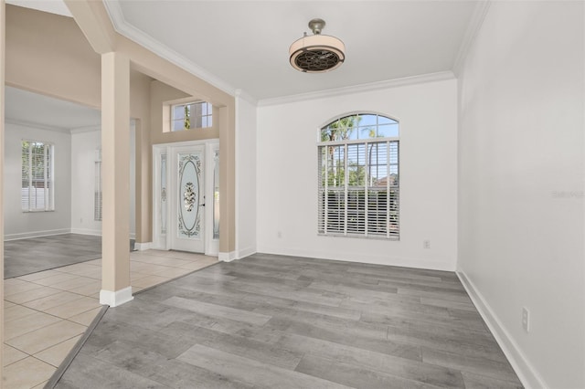 foyer entrance with baseboards, ornamental molding, and a healthy amount of sunlight