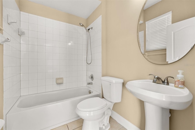full bath with a sink, toilet, tile patterned floors, baseboards, and shower / bathing tub combination