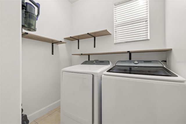 laundry room with laundry area, baseboards, independent washer and dryer, and light tile patterned flooring