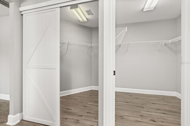 spacious closet with wood finished floors and visible vents