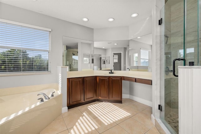 bathroom with tile patterned flooring, a shower stall, a garden tub, and vanity