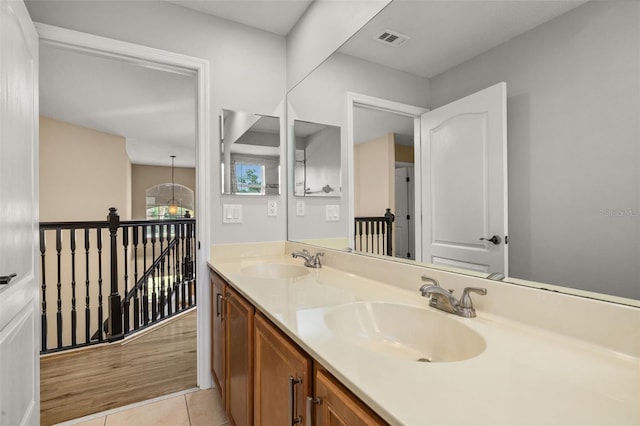 bathroom with visible vents, a sink, tile patterned flooring, and double vanity