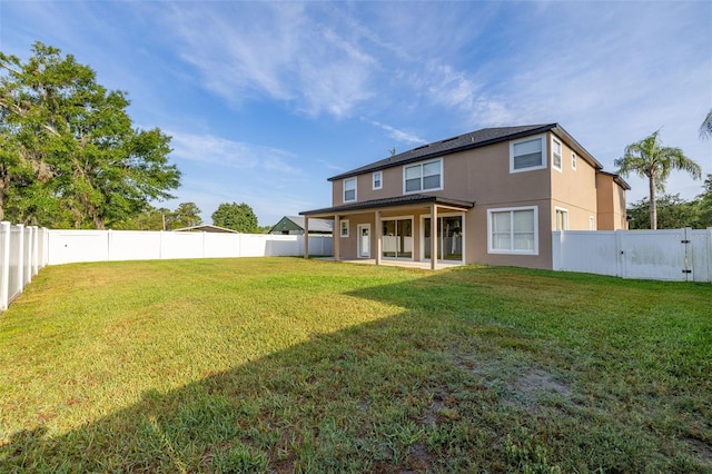 back of house featuring a fenced backyard, stucco siding, and a yard