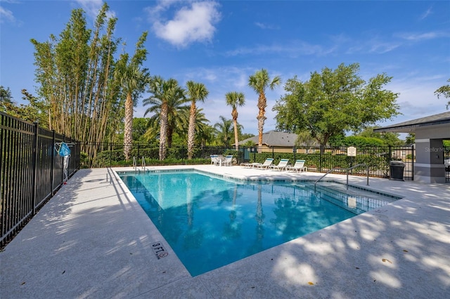 community pool featuring fence and a patio area