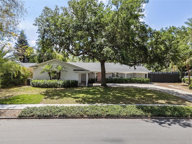 single story home with fence, driveway, and a front lawn
