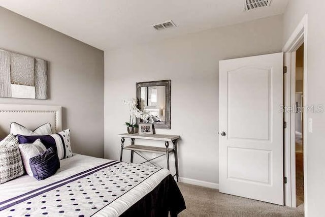 bedroom featuring visible vents, baseboards, and carpet