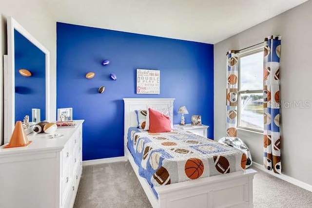 bedroom with baseboards and light colored carpet