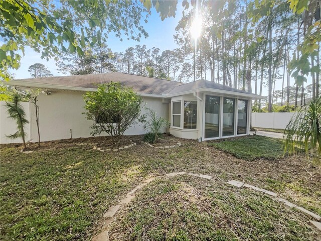 198 Bren Mar Ln, Palm Coast, FL 32137 - rear view of property with a sunroom, stucco siding, and fence