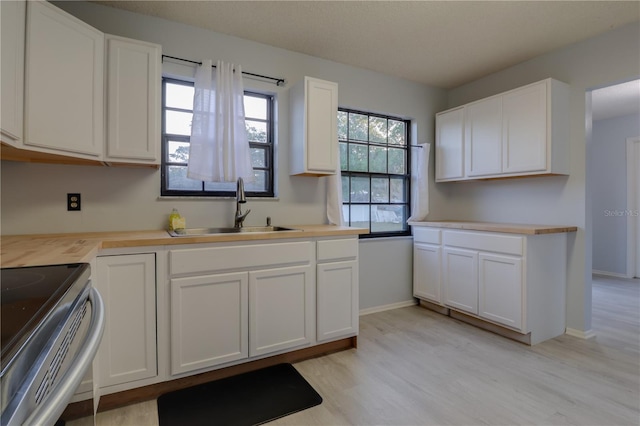 312 Oak Track Ter, Ocala, FL 34472 - kitchen featuring stainless steel electric stove, light wood-type flooring, white cabinets, a sink, and baseboards