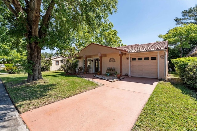 mediterranean / spanish house with a tile roof, a front lawn, a garage, stucco siding, and driveway