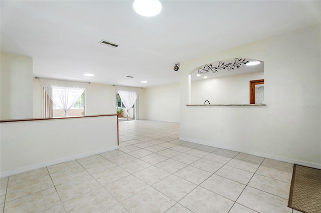 tiled empty room featuring visible vents, recessed lighting, and baseboards