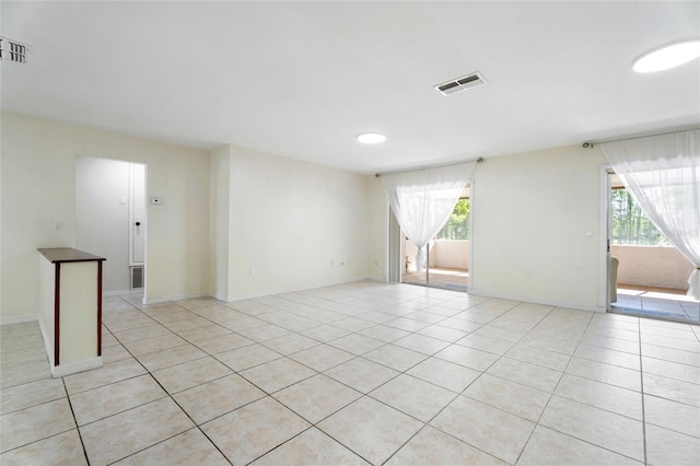 spare room featuring light tile patterned floors, plenty of natural light, and visible vents