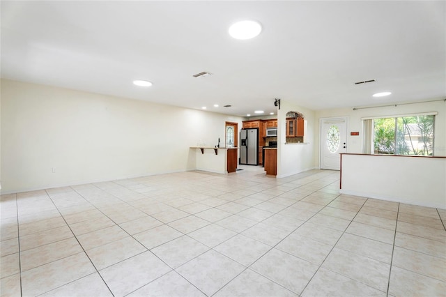 unfurnished living room with light tile patterned flooring, visible vents, and recessed lighting