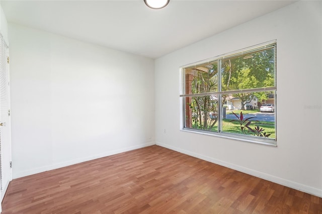 unfurnished room featuring baseboards and wood finished floors