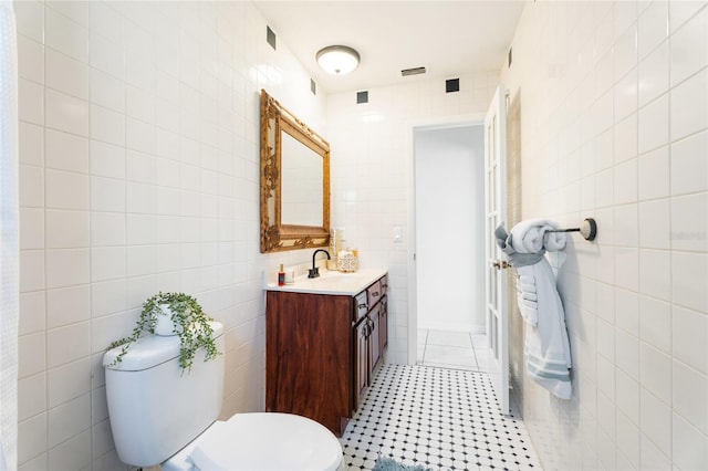 bathroom featuring visible vents, tile walls, tile patterned flooring, vanity, and toilet