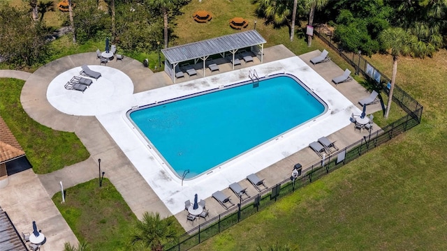 community pool featuring a lawn and fence