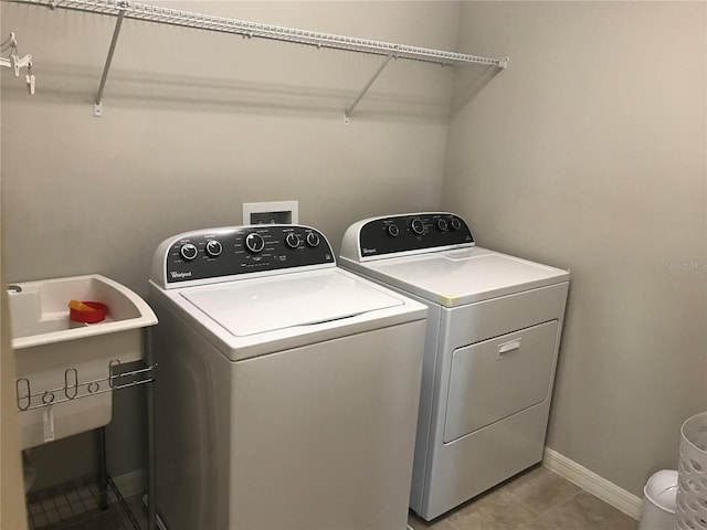 14841 Porter Rd, Winter Garden, FL 34787 - washroom featuring laundry area, light tile patterned floors, baseboards, and washing machine and dryer