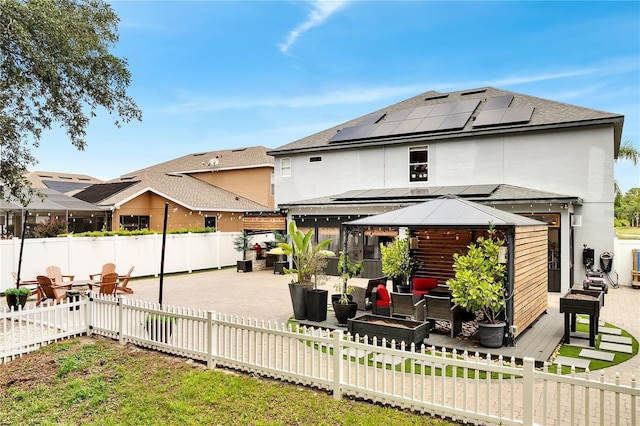 back of house with a sunroom, a patio, an outdoor living space, a fenced backyard, and a gazebo