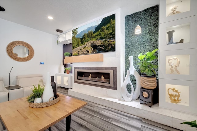 living room with recessed lighting, wood finished floors, and a high end fireplace