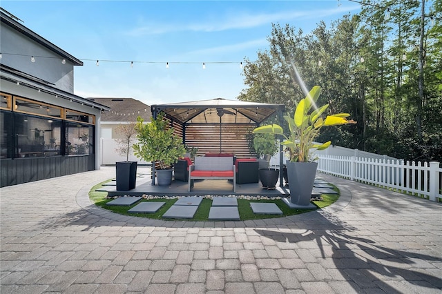 view of patio / terrace with an outdoor living space, fence, and a gazebo