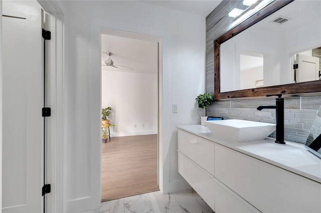 bathroom with marble finish floor, ceiling fan, vanity, baseboards, and visible vents
