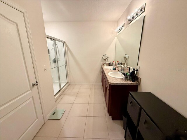 3702 Maidencain St, Clermont, FL 34714 - full bathroom featuring baseboards, double vanity, a stall shower, tile patterned floors, and a sink
