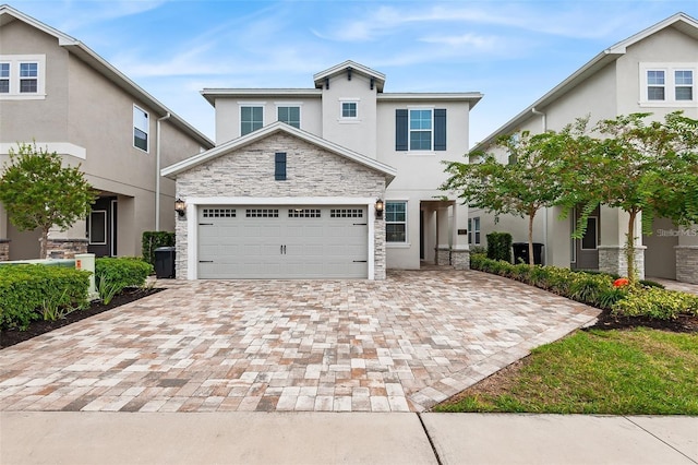 416 Southfield St, Kissimmee, FL 34747 - traditional-style house featuring an attached garage, stone siding, decorative driveway, and stucco siding