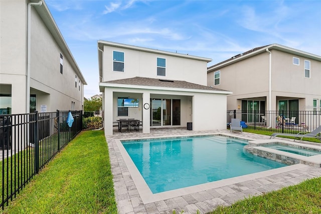 416 Southfield St, Kissimmee, FL 34747 - back of property featuring stucco siding, a patio area, a fenced backyard, a pool with connected hot tub, and a lawn