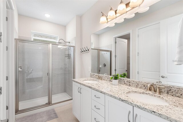 416 Southfield St, Kissimmee, FL 34747 - bathroom featuring a stall shower, double vanity, a sink, and tile patterned floors