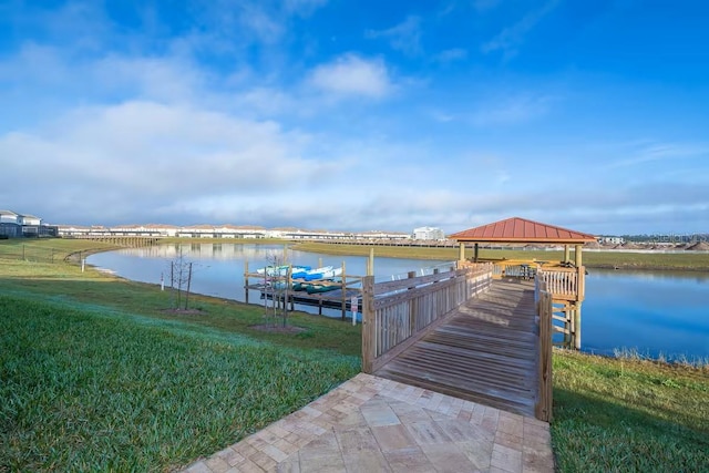 view of dock with a yard, a gazebo, and a water view
