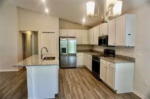 2607 Tulip Dr, Davenport, FL 33837 - kitchen with white cabinetry, appliances with stainless steel finishes, wood finished floors, a sink, and lofted ceiling