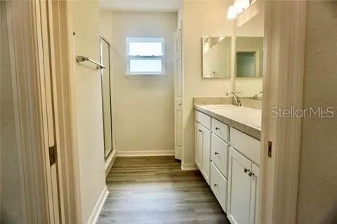 2607 Tulip Dr, Davenport, FL 33837 - bathroom with vanity, baseboards, a stall shower, and wood finished floors