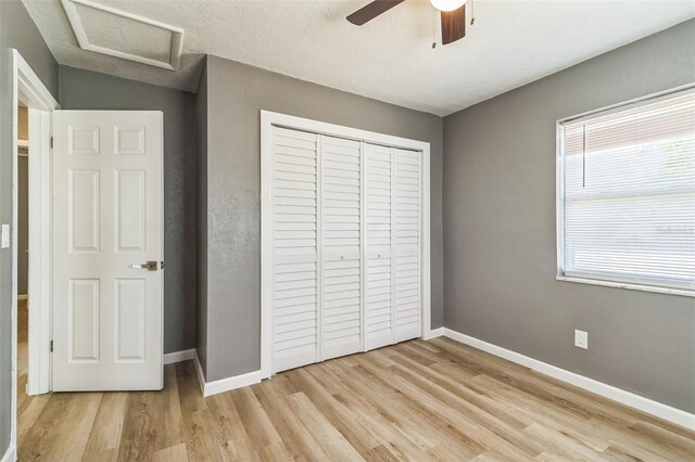 1234 Parker Ave, Deltona, FL 32725 - unfurnished bedroom with a closet, attic access, ceiling fan, baseboards, and light wood-type flooring