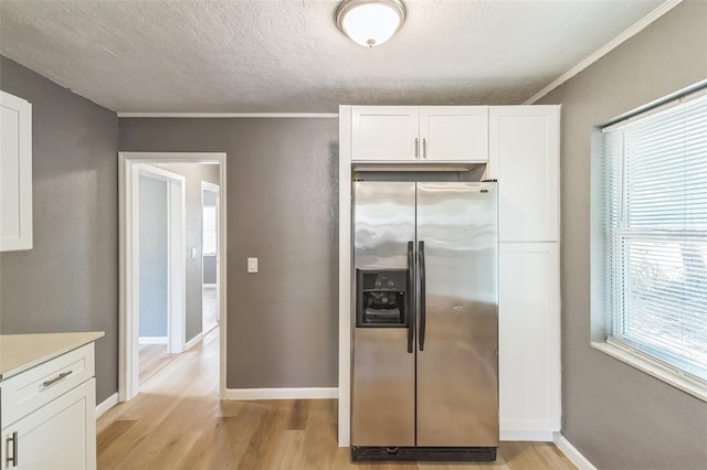 1234 Parker Ave, Deltona, FL 32725 - kitchen with stainless steel refrigerator with ice dispenser, white cabinetry, light wood-type flooring, and baseboards