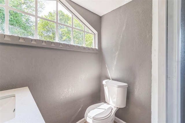 1234 Parker Ave, Deltona, FL 32725 - bathroom featuring baseboards, toilet, and a textured wall