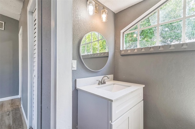 1234 Parker Ave, Deltona, FL 32725 - bathroom featuring vanity, visible vents, a textured wall, baseboards, and wood finished floors