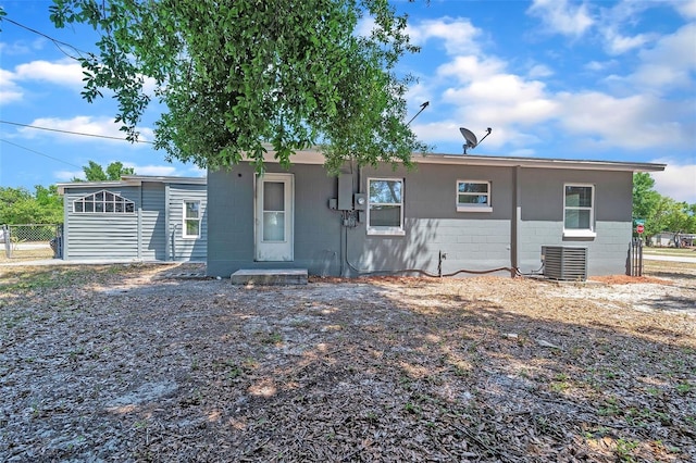 1234 Parker Ave, Deltona, FL 32725 - rear view of property featuring fence, concrete block siding, and central AC