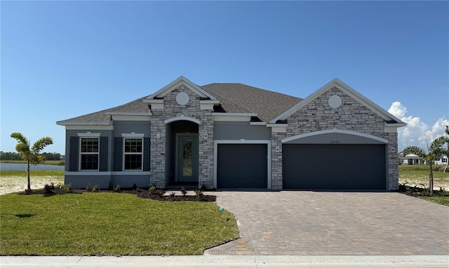 25126 Calusa Dr, Punta Gorda, FL 33955 - french country style house featuring a shingled roof, a garage, stucco siding, a front lawn, and decorative driveway